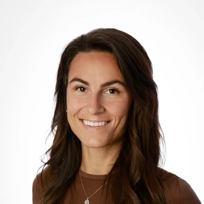 Courtney Kowalchuk smiling in a brown shirt.