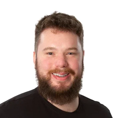 Mark Bourcet smiling in a black shirt.