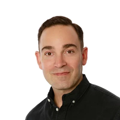 Ben Durie smiling in a black button up shirt.